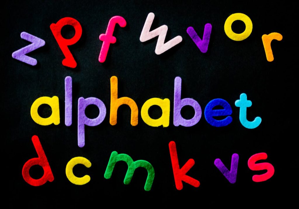 Vibrant colored alphabet letters arranged creatively on a black background for educational purposes.